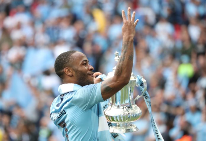 Raheem Sterling with Manchester City celebrates with FA Cup Trophy in 2019