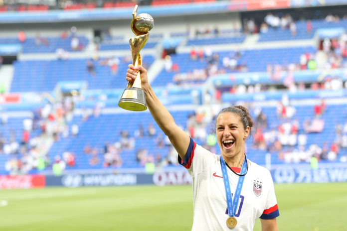 Carli Lloyd holding the 2019 FIFA Women's World Cup trophy