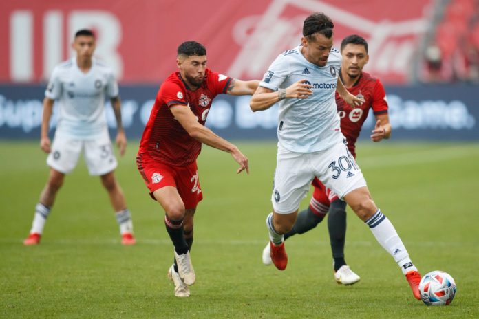 Chicago Fire midfielder Gaston Gimenez (30) dribbles the ball away from Toronto FC players
